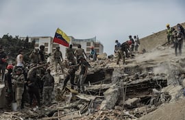 Rescatistas realizan labores de búsqueda de personas desaparecidas en una zona afectada por los terremotos, el domingo en Tanaguaneras, La Guaira (Venezuela).