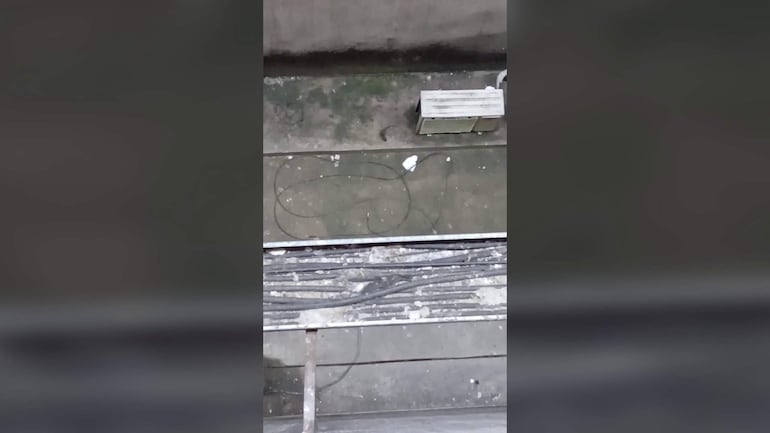 Espacio exterior descuidado en el Hospital de Trauma, con cables desordenados y un ambiente de abandono.