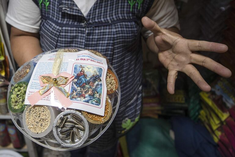 Una comerciante muestra productos esotéricos para rituales de fin de año este martes, en el Mercado de Sonora, en Ciudad de México .