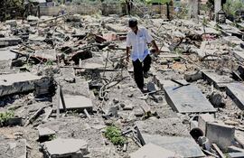 Un hombre camina entre escombros en un cementerio dañado por un bombardeo israelí en la localidad libanesa de Srifa.