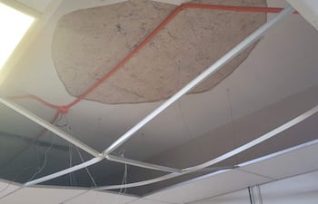 Techo dañado en el área de obstetricia del IPS, con panel desprendido y cable eléctrico visible, sin personas en la imagen.
