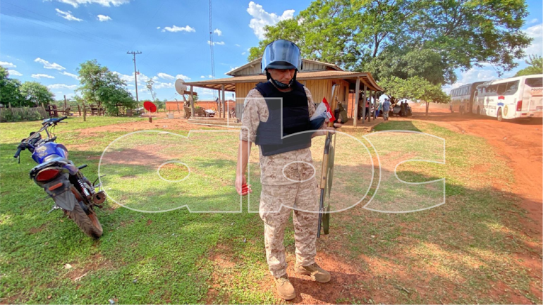Un uniformado sostiene un arma de fuego y balas que fueron incautadas.