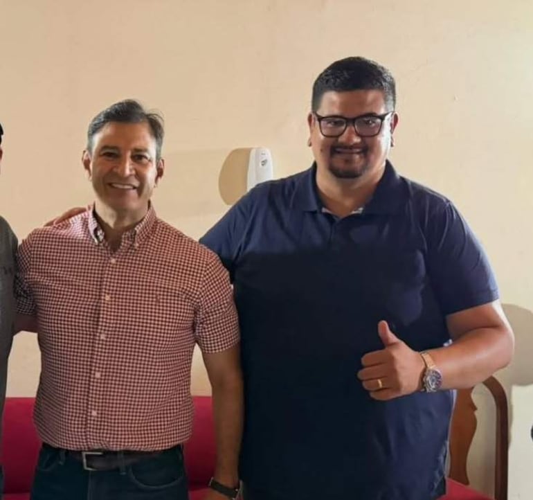 Mario Gustavo Pineda sonríe con camisa de cuadros, flanqueado por Silvio Beto Ovelar y Hugo Farías, ambos sonrientes en un ambiente informal.