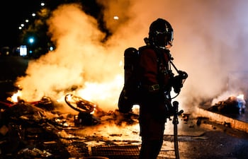 Un bombero francés interviene ante una barricada en llamas en una calle, mientras continúan por segundo día los enfrentamientos entre la policía antidisturbios y los manifestantes durante las protestas a nivel nacional contra el alto costo de la vida en París, Francia.