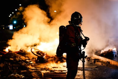 Un bombero francés interviene ante una barricada en llamas en una calle, mientras continúan por segundo día los enfrentamientos entre la policía antidisturbios y los manifestantes durante las protestas a nivel nacional contra el alto costo de la vida en París, Francia.