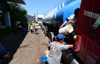 Dos personas trabajan en la descarga del combustible del camión cisterna sobre la avenida Madame Lynch.