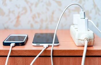 Imagen ilustrativa: dos celulares conectados a un cargador.