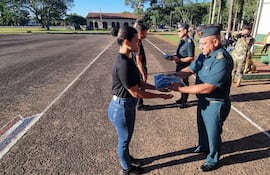 El general de división, Narciso López, realiza la entrega del uniforme a una de las cimeforistas durante la ceremonia de recibimiento.