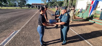 El general de división, Narciso López, realiza la entrega del uniforme a una de las cimeforistas durante la ceremonia de recibimiento.