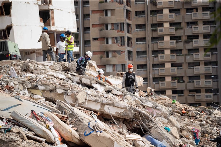 Voluntarios y rescatistas trabajan este domingo en un edificio derrumbado por el doble terremoto en Catia La Mar (Venezuela). A 11 días del doble terremoto que sacudió Venezuela, las labores se concentran en la remoción de escombros de los edificios colapsados en La Guaira (norte), el estado más golpeado por el desastre, mientras las operaciones de búsqueda y rescate disminuyen a medida que pasan los días.