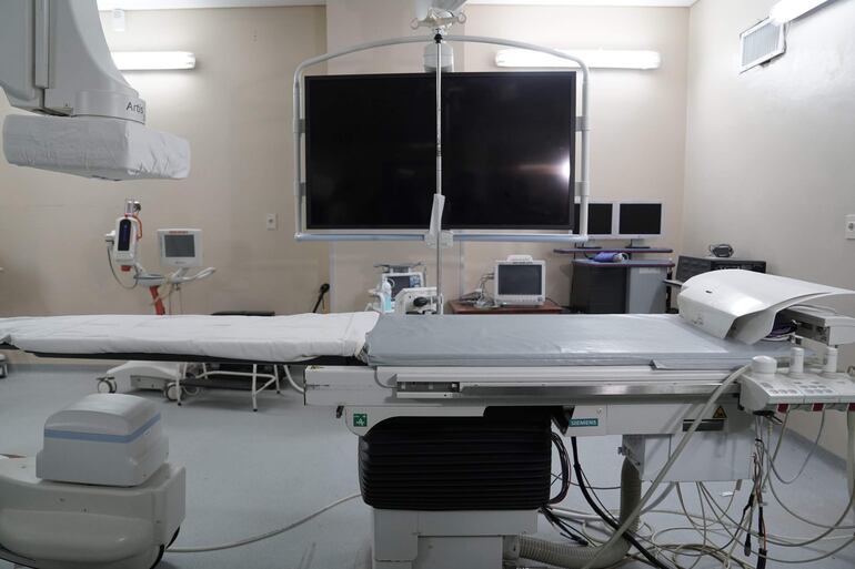 Quirófano iluminado con monitor y equipos médicos; no hay personas visibles.