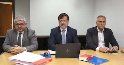 Óscar Boidanich con camisa blanca y blazer oscuro, Claudio Lovera con traje oscuro, y César Alfonso en reunión con documentos y laptop.