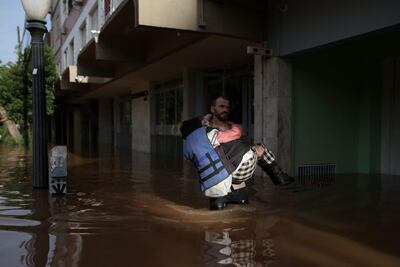 Un voluntario asiste a una víctima de las inundaciones en Porto Alegre, Río Grande do Sul, Brazil.