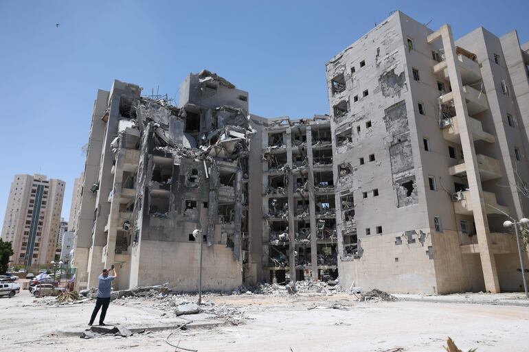 Una persona se encuentra cerca del lugar donde un misil iraní impactó una zona residencial el 24 de junio en Beer Sheva, al sur de Israel, durante un alto el fuego mediado por Estados Unidos entre Irán e Israel. El Magen David Adom (MDA), el servicio nacional de emergencias de Israel, reportó al menos 28 muertos y cientos de heridos en ataques de represalia iraníes desde que Israel inició su ofensiva en Irán el 13 de junio, contra instalaciones nucleares, militares y energéticas. 