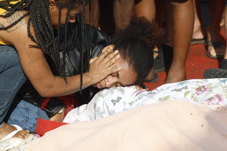 Una mujer llora sobre un cuerpo sin vida en una calle este miércoles, en Río de Janeiro (Brasil). 