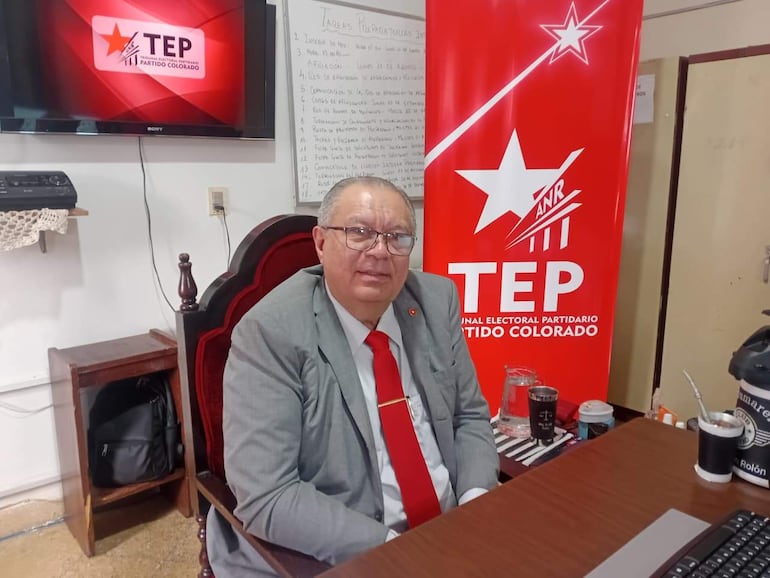 Dr. Rubén Rolón, hombre de mediana edad con vestimenta formal, muestra una expresión tranquila durante una reunión.