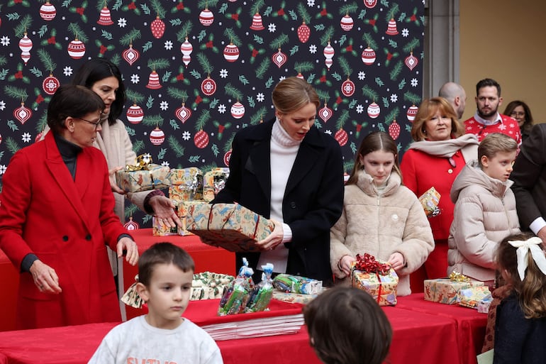 La princesa Estefanía de Mónaco, la princesa Charlene de Mónaco, la princesa Gabriella de Mónaco y el príncipe Jacques de Mónaco distribuyen regalos de Navidad a los niños. (Valery HACHE / AFP) 