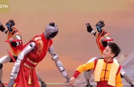 Robots humanoides bailan con un adolescente chino durante el show televisivo por el Año Nuevo lunar, en Pekín. (captura de video)