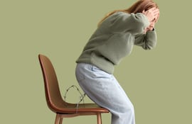 Mujer con dolor al sentarse, concepto de hemorroides.