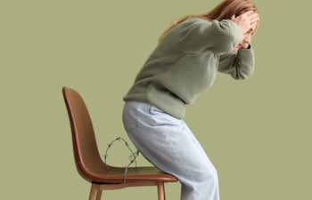 Mujer con dolor al sentarse, concepto de hemorroides.