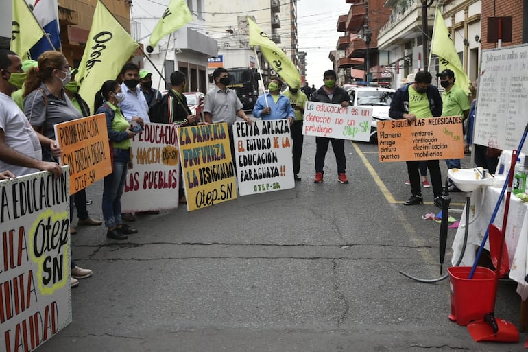 Docentes de la de la Organización de Trabajadores de la Educación Sindicato Nacional (OTEP-SN) se manifestaron este miércoles frente al edificio central del Ministerio de Educación, en el microcentro de Asunción, para exigir mejores condiciones para el regreso presencial a clases.