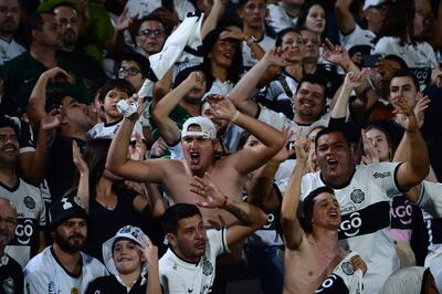 Los hinchas de Olimpia celebran un gol en el partido de los octavos de final de la Copa Libertadores ante Flamengo en el estadio Defensores del Chaco, en Asunción, Paraguay.