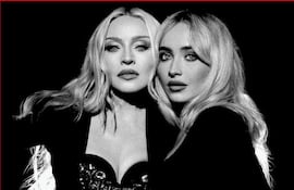 Madonna y Sabrina Carpenter sonríen, luciendo ropa moderna y colorida en un ambiente de estudio.