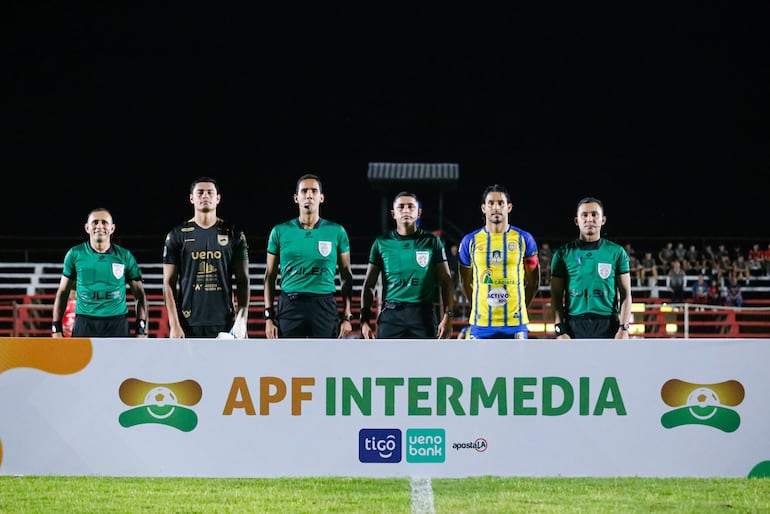 La terna arbitral posa junto a los dos capitanes.