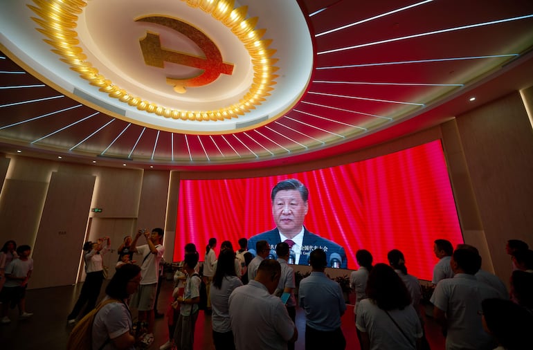 Ciudadanos observan el discurso del presidente de China, Xi Jinping, durante el congreso del Partido Comunista chino, en Pekín.
