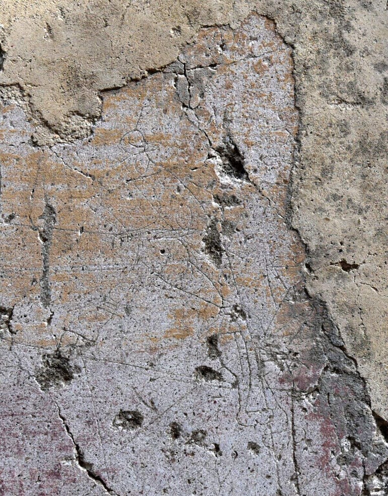 Esta fotografía tomada en Pompeya en 2025 y difundida el 3 de febrero de 2026 por el proyecto de investigación “Bruits de couloir” de la Universidad de Quebec en Montreal, muestra grafitis incisos en una pared del corredor que conecta los teatros de Pompeya.