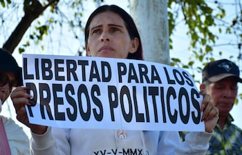 Una mujer muestra un cartel con la leyenda "Libertad para los presos políticos" durante una manifestación para exigir la libertad de los presos políticos venezolanos frente a la cárcel de Tocuyito, cerca de Valencia, Venezuela.