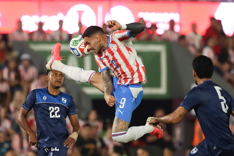 Antonio Sanabria (c) de Paraguay disputa un balón con Anyelo Velásquez (i) de Nicaragua este viernes, en un partido amistoso entre Paraguay y Nicaragua previo a la Copa Mundial de Fútbol 2026 en el estadio Defensores del Chaco en Asunción (Paraguay). 