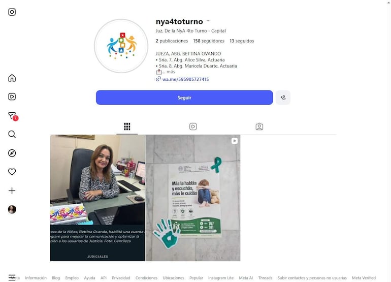 Mujer con cabello castaño y blusa blanca y negra, sentada en un escritorio frente a un cartel informativo sobre justicia infantil.