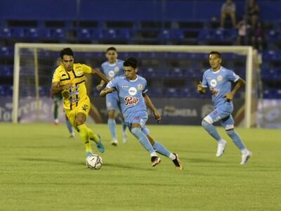 Jorge Núñez (c), futbolista de Resistencia, pelea por el balón ante la marca de Pablo Ayala, jugador del Sportivo Trinidense, durante el partido de la primera rueda del torneo Apertura 2023 del fútbol paraguayo en el estadio Luis Alfonso Giagni, en VIlla Elisa.