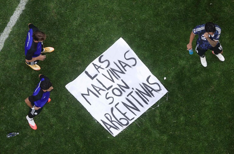 La pancarta hace referencia al Territorio Británico de Ultramar de las Islas Malvinas (Falkland Islands), ubicadas frente a la costa de Argentina. Argentina disputa la soberanía británica sobre las islas y se refiere a ellas como Las Malvinas.