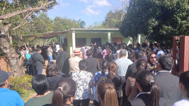 Multitud de personas vestidas de forma solemne, con expresiones de tristeza en un acto conmemorativo en Colonia Independencia.