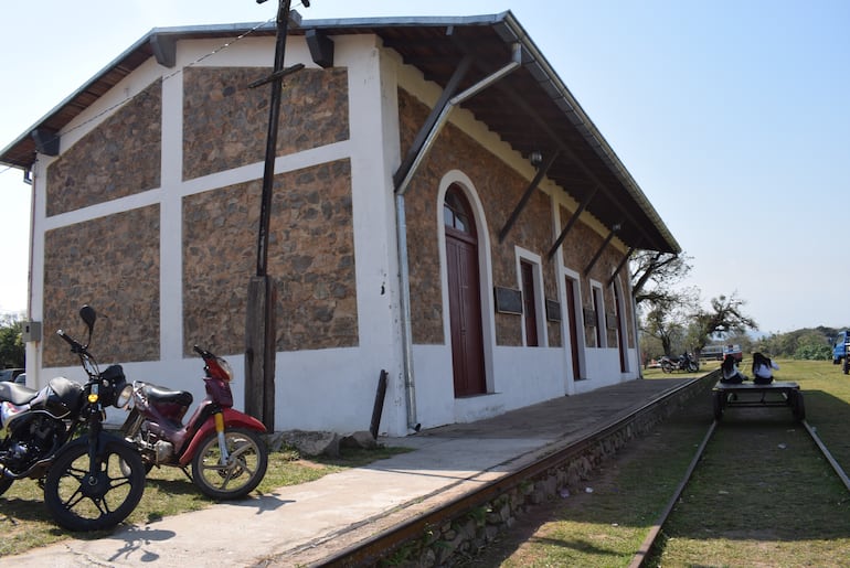 Frente a la ex estación del tren se observa una antigua zorra que se desplaza sobre lo que fue la vía férrea, en Escobar.
