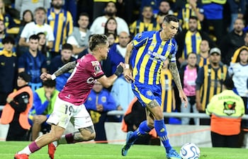 Angel Di María (d) de Rosario disputa un balón con Layan Loor de Independiente del Valle este jueves, durante un partido de la fase de grupos de la Copa Libertadores entre Rosario Central e Independiente del Valle en el estadio Gigante de Arroyito en Rosario (Argentina).
