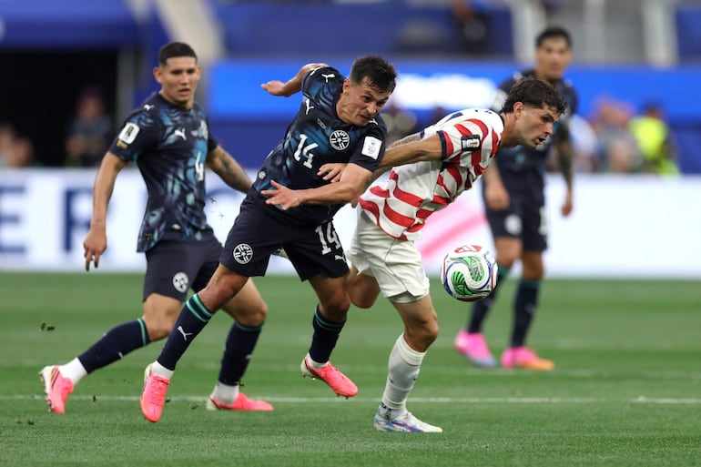 Christian Pulisic de los Estados Unidos controla el balón bajo la presión de Andrés Cubas de Paraguay durante el partido del Grupo D de la Copa Mundial de la FIFA 2026 entre Estados Unidos y Paraguay en el Los Angeles Stadium.