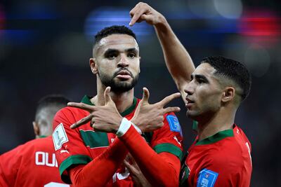Morocco's forward #19 Youssef En-Nesyri (L) celebrates scoring  the opening goal with Morocco's defender #02 Achraf Hakimi during the Qatar 2022 World Cup quarter-final football match between Morocco and Portugal at the Al-Thumama Stadium in Doha on December 10, 2022. (Photo by PATRICIA DE MELO MOREIRA / AFP)