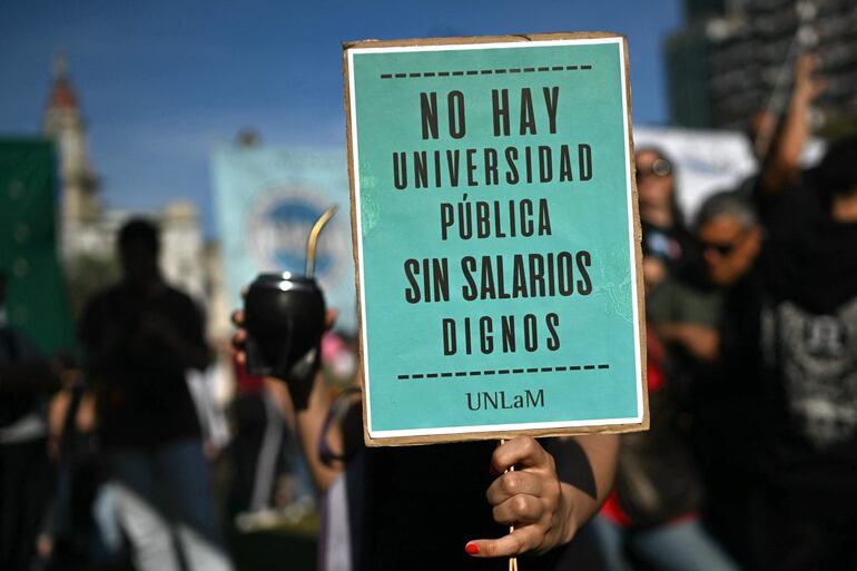 Una mujer sostiene un cartel que dice “No hay universidad pública sin salarios dignos” durante una manifestación frente al Congreso Nacional contra los vetos del presidente argentino Javier Milei