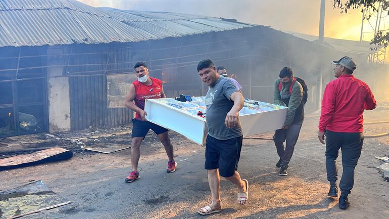 Comerciantes tratan de salvar sus pertenencias durante el gran incendio en el Mercado Municipal de Itauguá