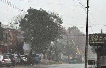 Calle de San Ignacio bajo intensa lluvia, sin personas visibles, con vehículos estacionados y agua acumulada en la calzada.