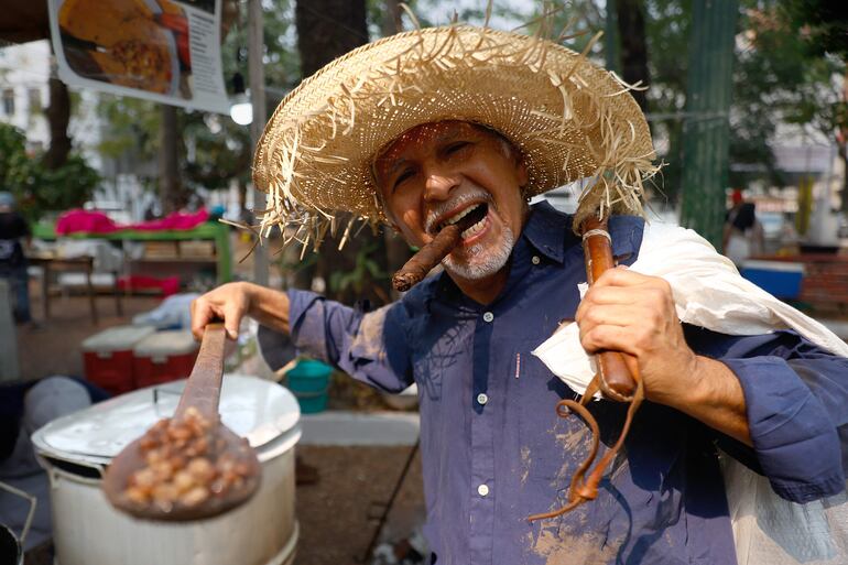 -FOTODELDÍA- AME3982. ASUNCIÓN (PARAGUAY), 01/10/2024.- Un hombre caracterizado como Karaí Octubre, un personaje de la mitología guaraní, participa durante la celebración del jopará, este martes en la Plaza Uruguaya, en Asunción (Paraguay). Los paraguayos madrugaron este martes, como cada 1 de octubre, a preparar el jopará, un guiso elaborado a base de porotos (frijoles), maíz, calabaza, verduras y carnes que aleja de sus cocinas al "Karaí Octubre" (Señor Octubre), a quien la tradición popular vincula con la escasez y el hambre. EFE/Juan Pablo Pino