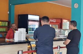 Aníbal Cayetano Ramírez Ortiz (campera roja) habla con dos policías durante la toma de rehén en Concepción.