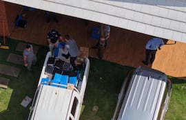 Una comitiva fiscal-policial alza documentos incautados durante uno de los allanamientos.