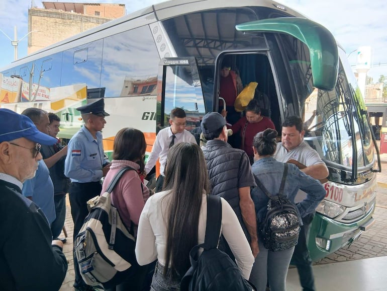 Un grupo de pasajeros aborda un bus en la Terminal de Ómnibus de Villarrica.