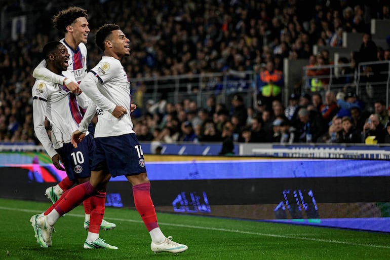El delantero francés Ousmane Dembélé (i) celebra tras marcar el segundo gol de su equipo con sus compañeros Désiré Doué (d) y Maghnes Akliouche, durante el partido de fútbol de la L1 francesa entre el RC Estrasburgo Alsacia y el París Saint-Germain (PSG) en el Stade de la Meinau.