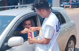 Un voluntario de la AMSAP recibe el aporte de un automovilista en la rotonda de Presidente Franco.