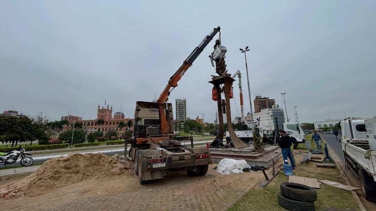 Tres trabajadores en la Costanera, cerca de un camión y grúa, con cielo nublado al fondo.
